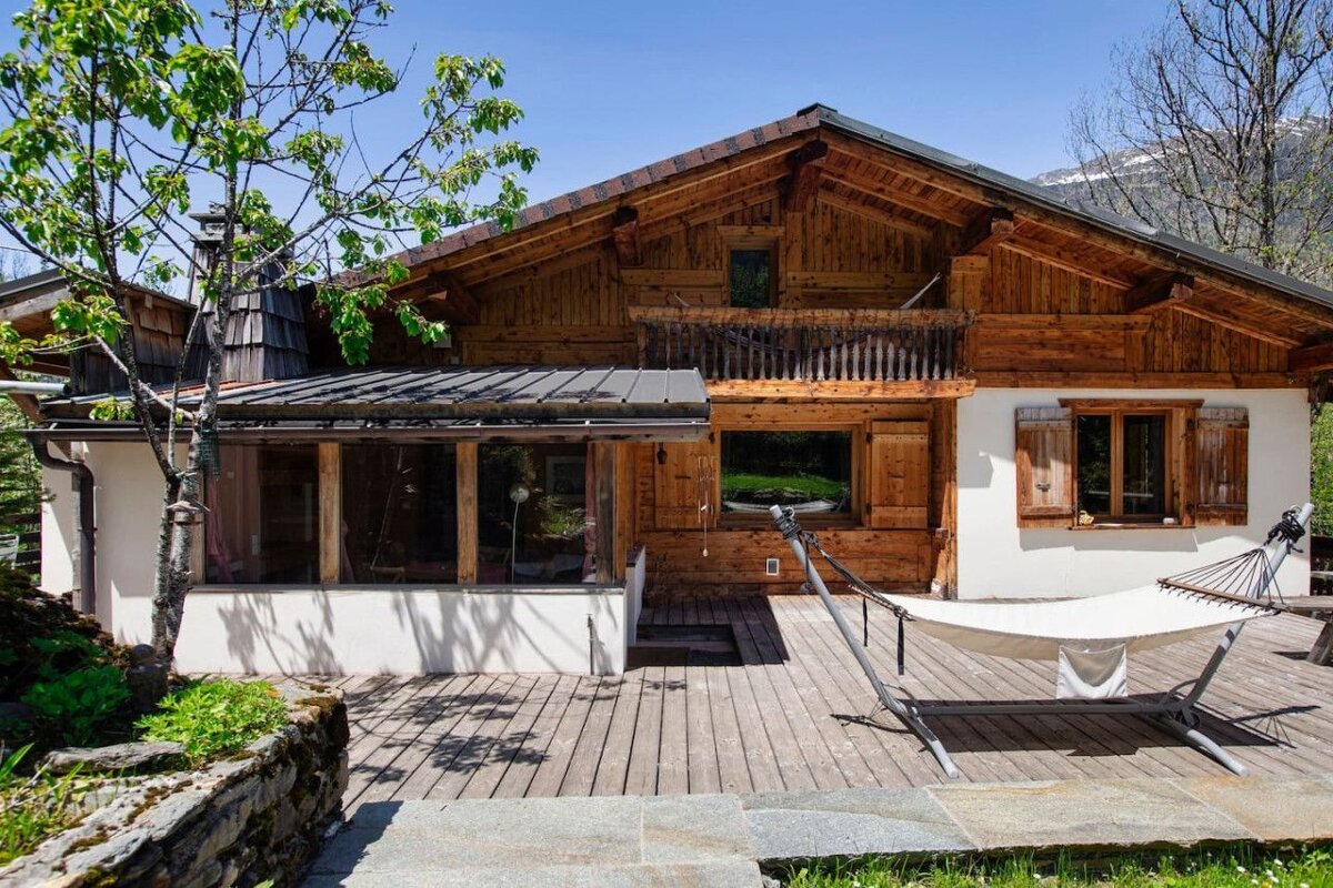A wooden house with a hammock in front of it