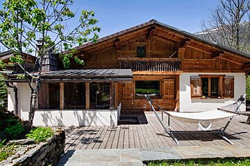 A wooden house with a hammock in front of it