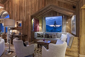 A living room with a couch and chairs and a window