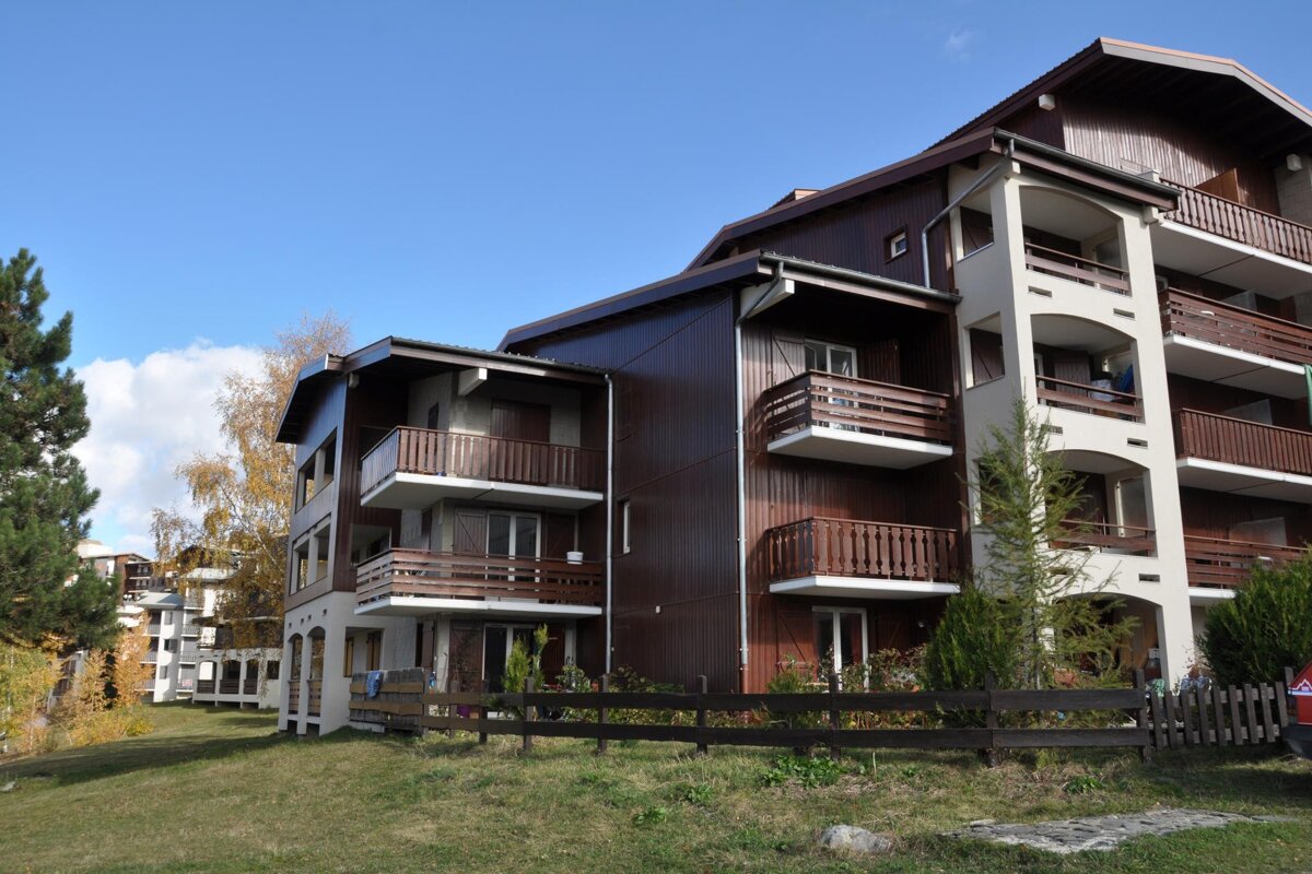 A building with balconies and a fence in front of it