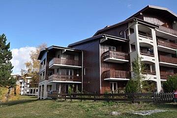 A building with balconies and a fence in front of it