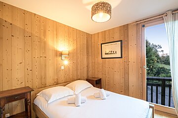 A bedroom with a bed and a picture on the wall that says