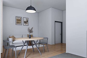 A modern, minimalist dining and living area features a round wooden table with gray chairs, a white sofa, abstract art, and a black pendant light.