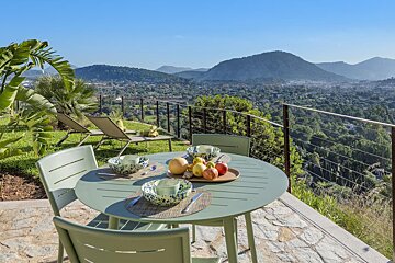 A table with a tray of fruit on it with mountains in the background