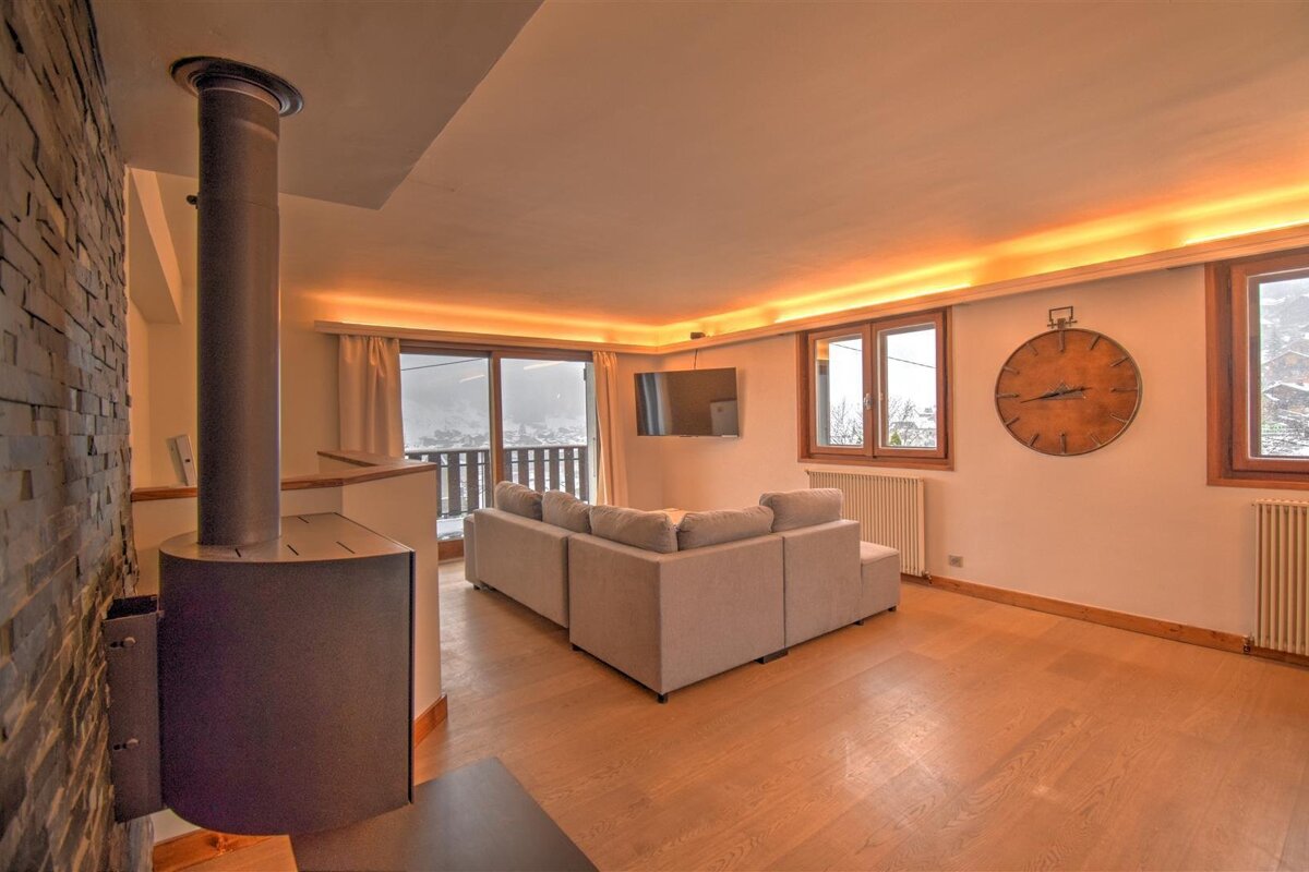 A living room with a couch and a clock on the wall