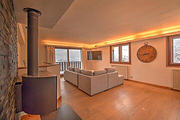 A living room with a couch and a clock on the wall