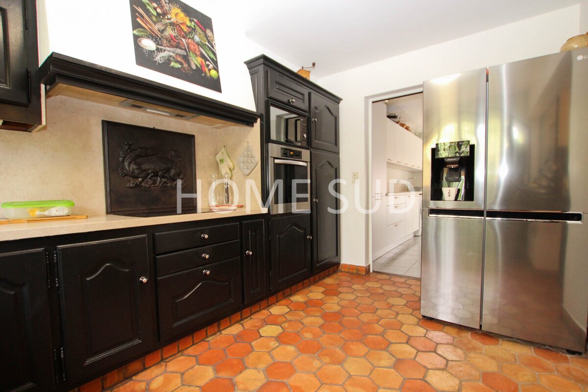 A kitchen with black cabinets and a stainless steel refrigerator that says home sub