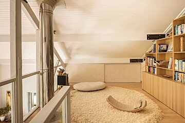 A room with a rug and a bookshelf with one of the books on the shelves being titled ' a brief history '