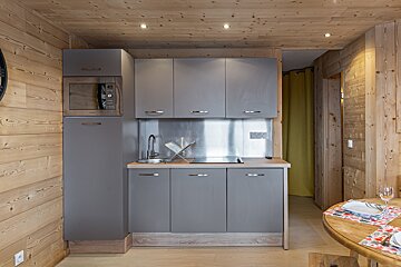 A kitchen with gray cabinets and a stainless steel counter top