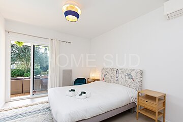 A bedroom with a bed and a sliding glass door that says home sud