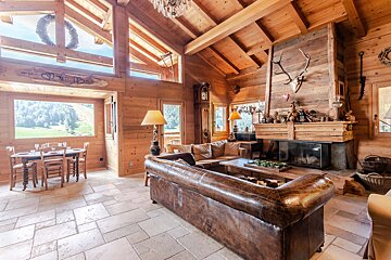 A living room with a leather couch and a fireplace