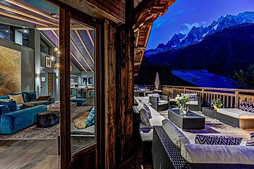 A balcony with a view of the mountains at night