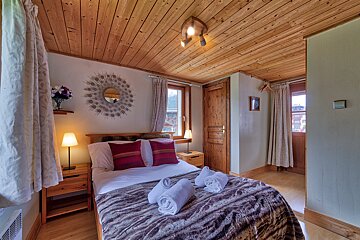 A bedroom with a bed and a mirror on the wall