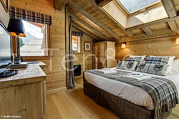 A bedroom with a large bed and a flat screen tv