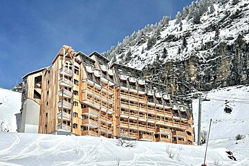 A large building with a lot of windows is surrounded by snow