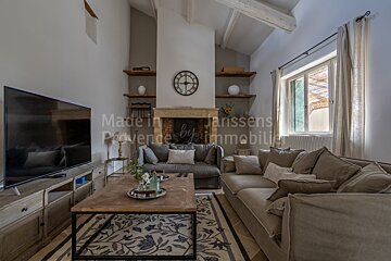 A living room with a couch and a television made in provence by immobilier