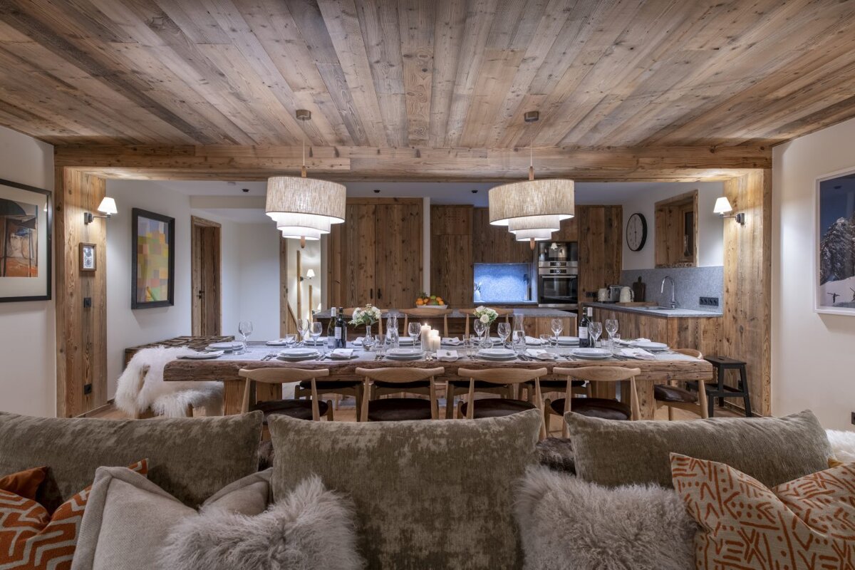 A dining room with a wooden table and chairs