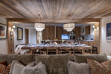 A dining room with a wooden table and chairs