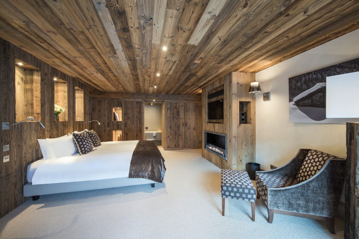 A bedroom with a large bed and a fireplace