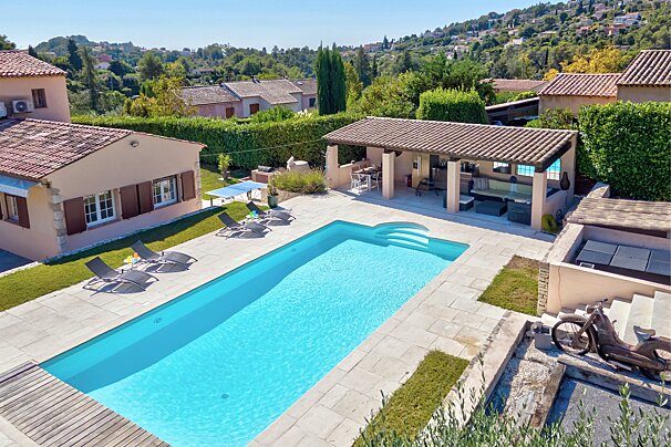 An aerial view of a house with a large swimming pool