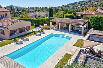 An aerial view of a house with a large swimming pool