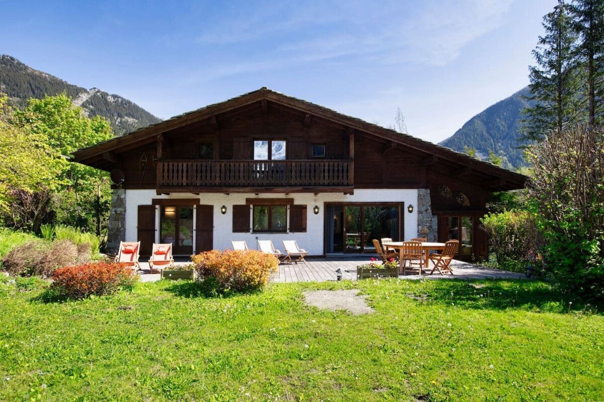 A house with a deck and chairs in front of it