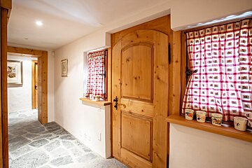 A wooden door with a red and white checkered curtain