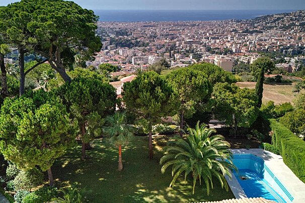 An aerial view of a city with a swimming pool in the foreground