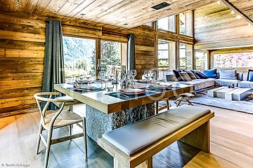 A dining room table with plates and glasses on it