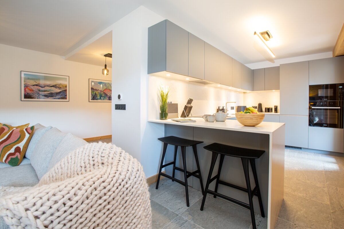 A kitchen with stools and a bowl on the counter