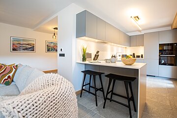 A kitchen with stools and a bowl on the counter