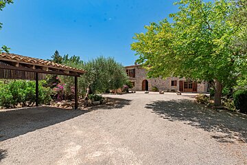 A gravel driveway leading to a stone house