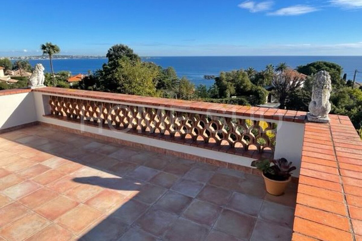 A balcony with a brick railing overlooking the ocean