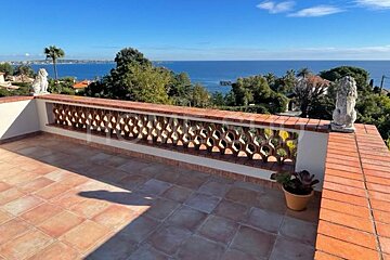 A balcony with a brick railing overlooking the ocean