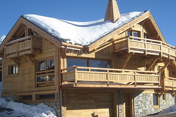 A large wooden house with snow on the roof