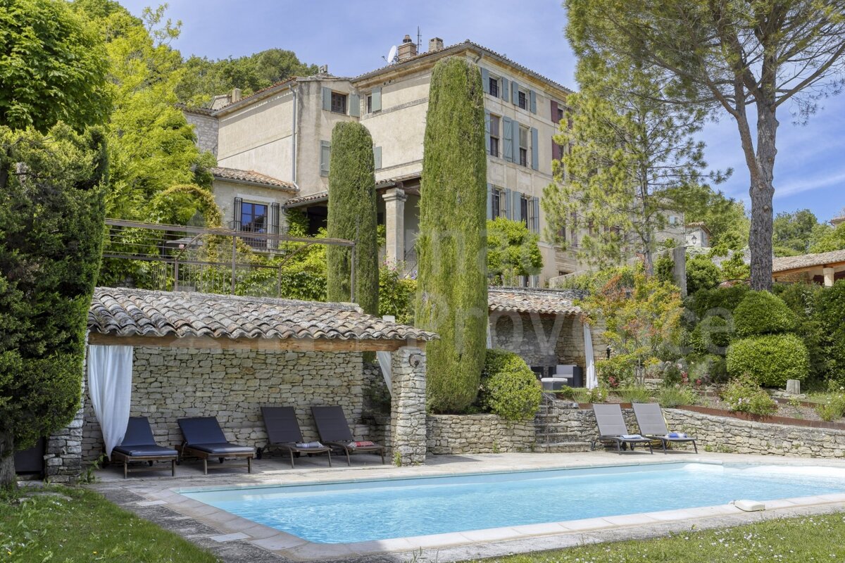 A large house with a swimming pool in front of it