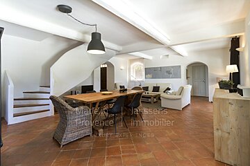 A living room with a table and chairs and a sign that says provence immobilier