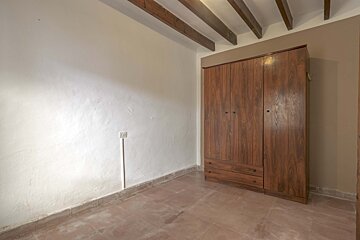 An empty room with a wooden wardrobe and drawers