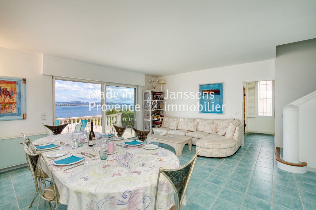 A living room with a table and chairs and the words made in provence immobilier on the wall