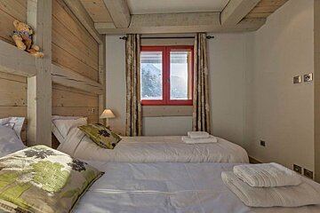 A bedroom with two beds and a red window