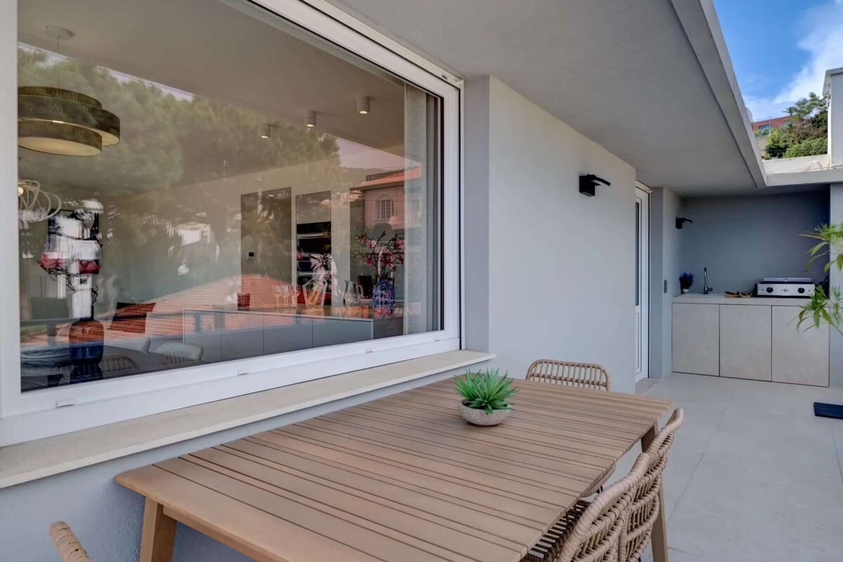 A table with a plant on it sits in front of a window