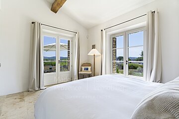 A bedroom with a bed and a chair with the words made in provence on the bottom
