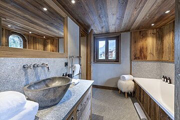A bathroom with a stone sink and a bathtub