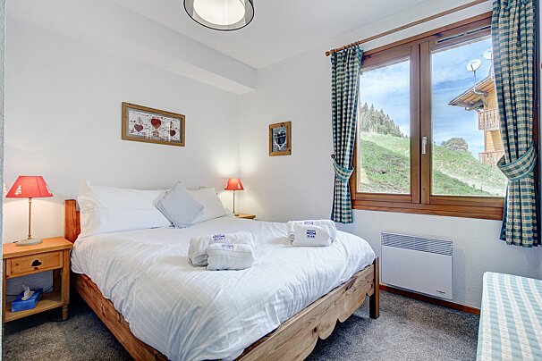 A bedroom with a king size bed and a window