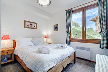 A bedroom with a king size bed and a window