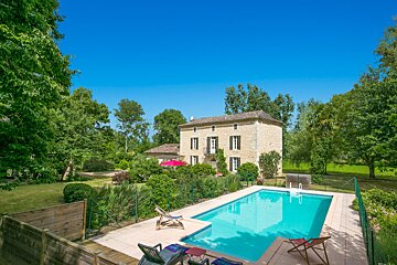 A large house with a swimming pool in front of it