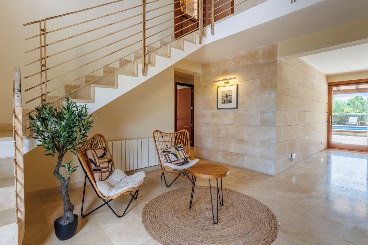 A staircase with two chairs and a table underneath it