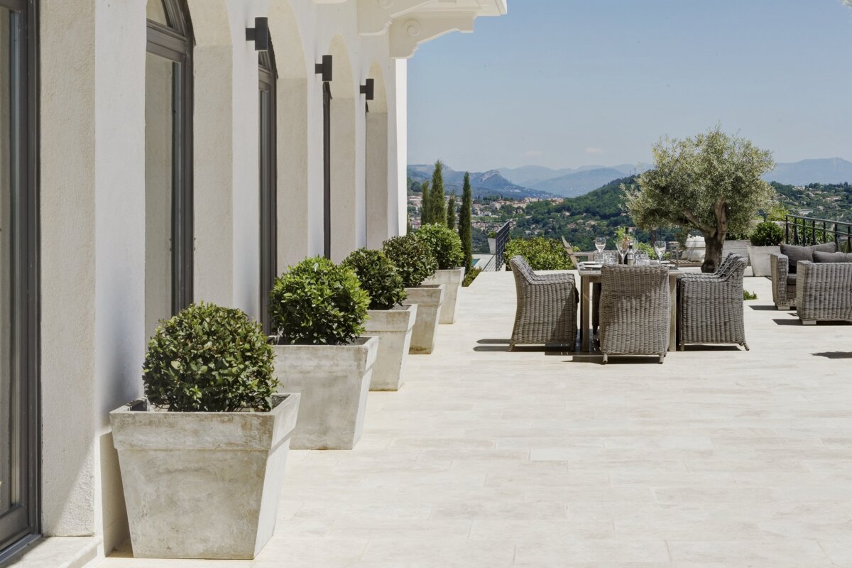 A patio with a table and chairs and potted plants