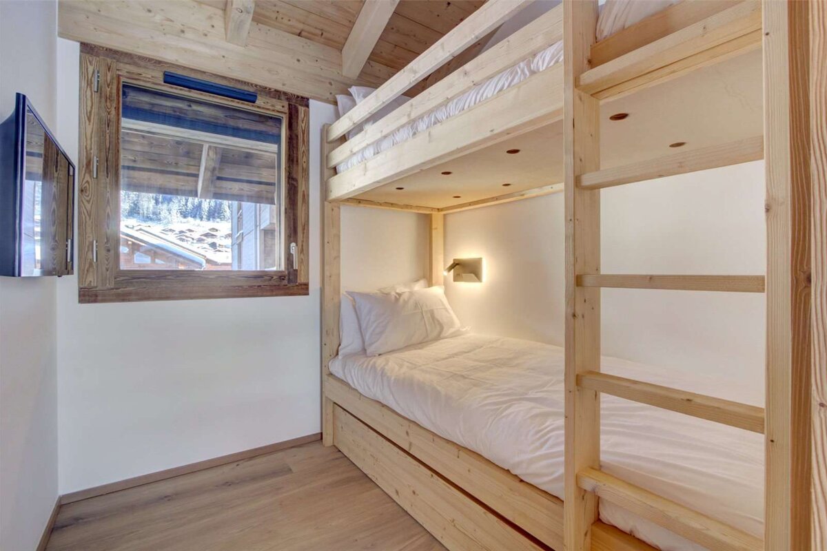 A bunk bed in a room with a window