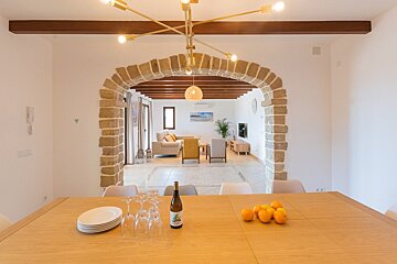 A bottle of wine sits on a table next to oranges